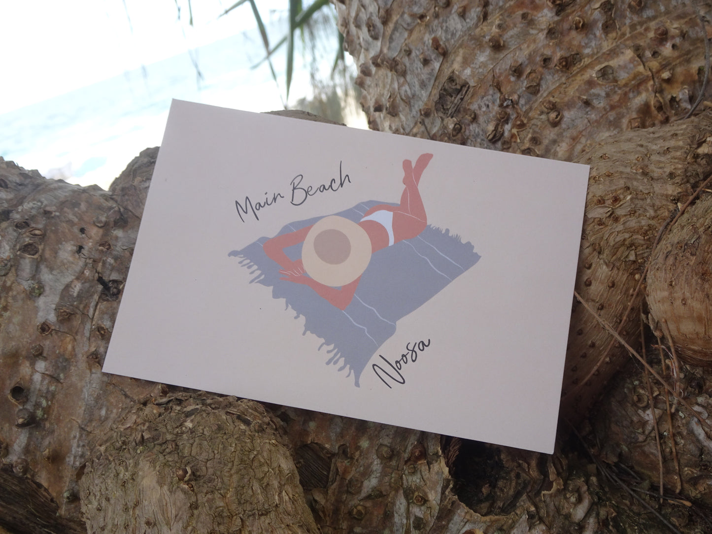 Laying woman, Main beach Noosa, ecofriendly postcard