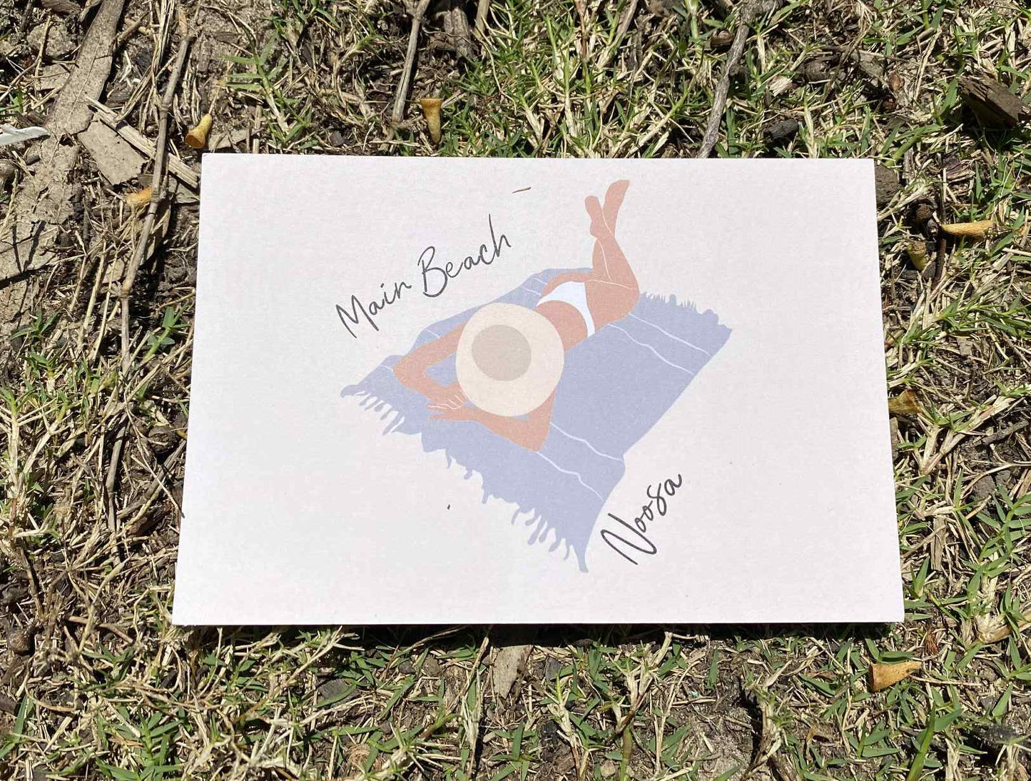 Laying woman, Main beach Noosa, ecofriendly postcard