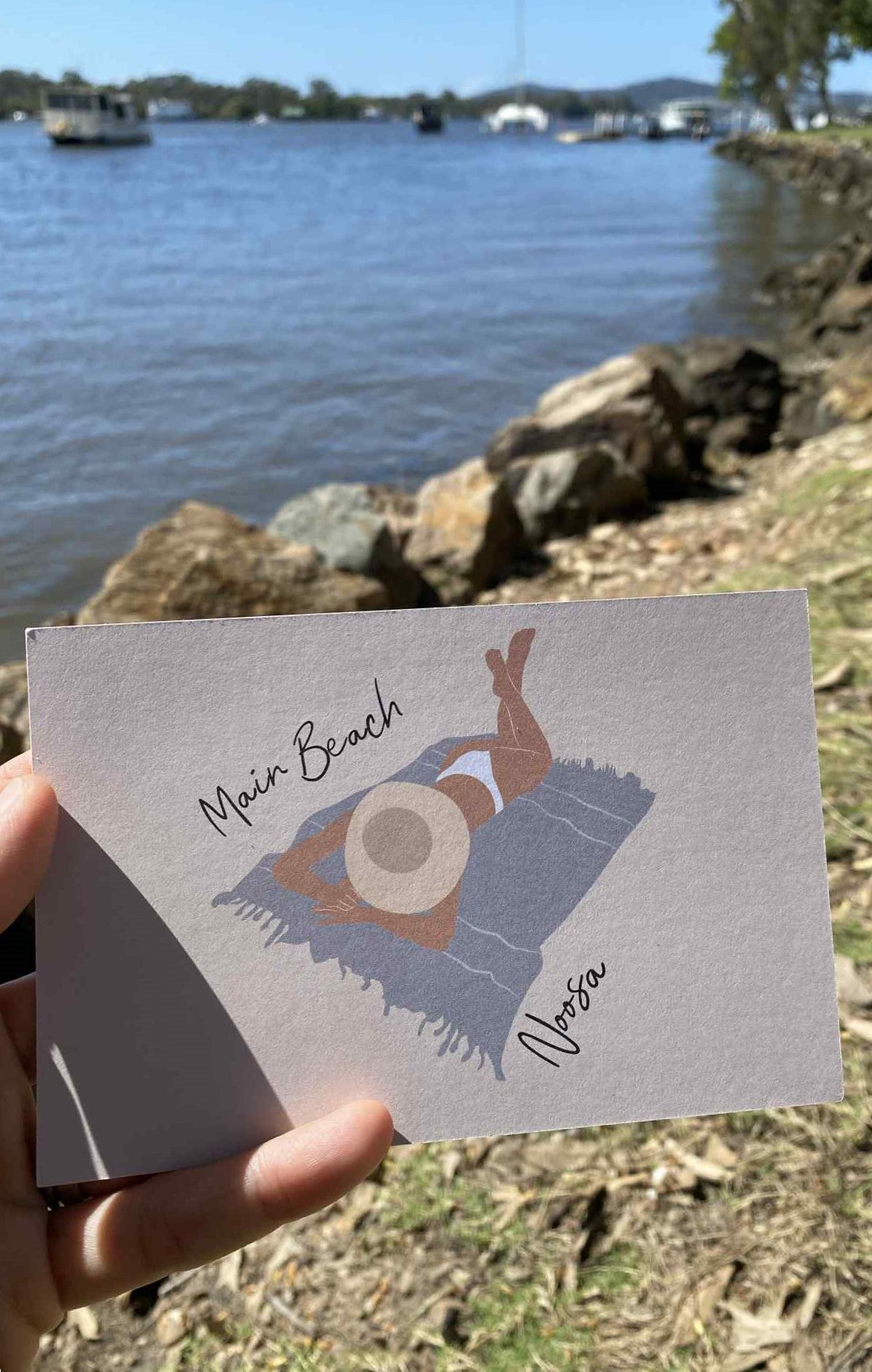 Laying woman, Main beach Noosa, ecofriendly postcard